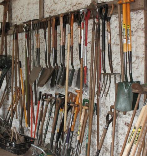 Shed wall with racks of hanging shovels and pitchforks