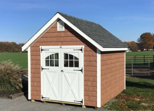 Brown cape shed with white trim, white double doors, grey roof, and a vent