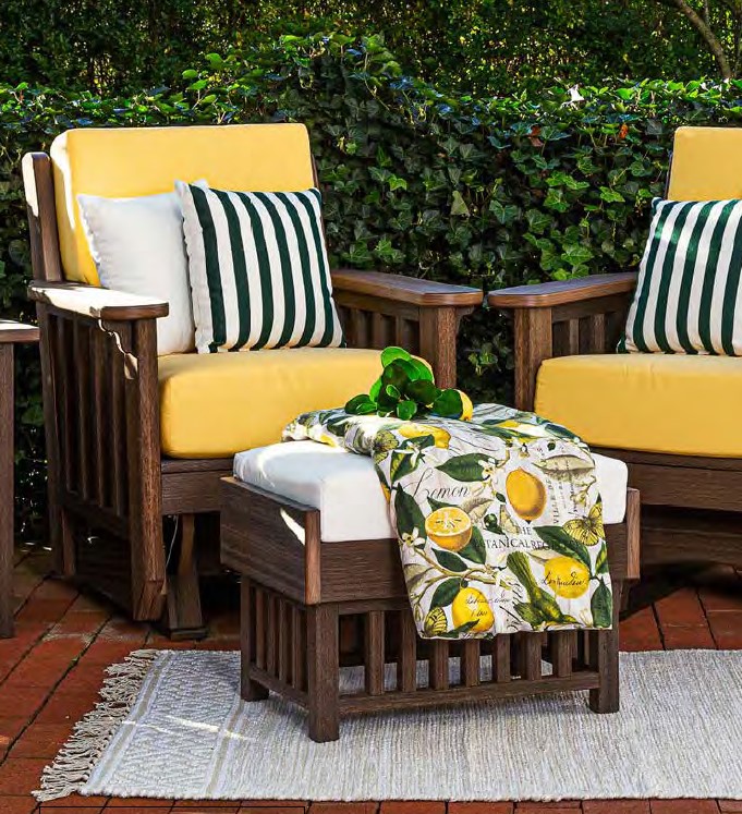 Brown poly wood arm chair and ottoman set with yellow cushions, white and black striped throw pillows, and a lemon patterned blanket.