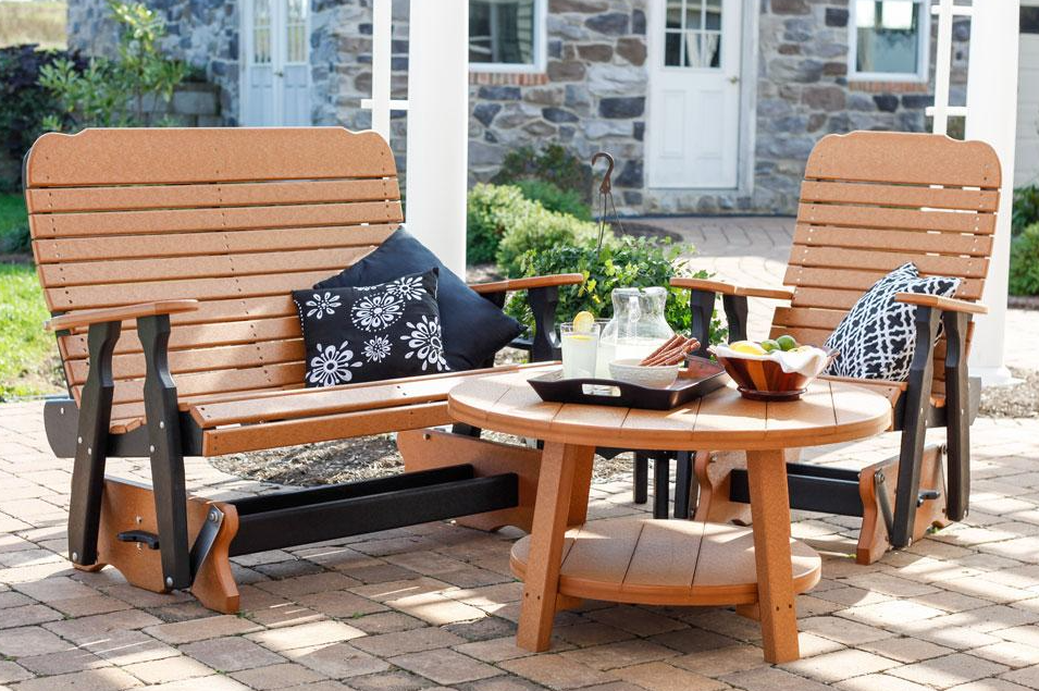 Tan and black poly furniture set with a chair and loveseat with black and white pillows and a tan round table